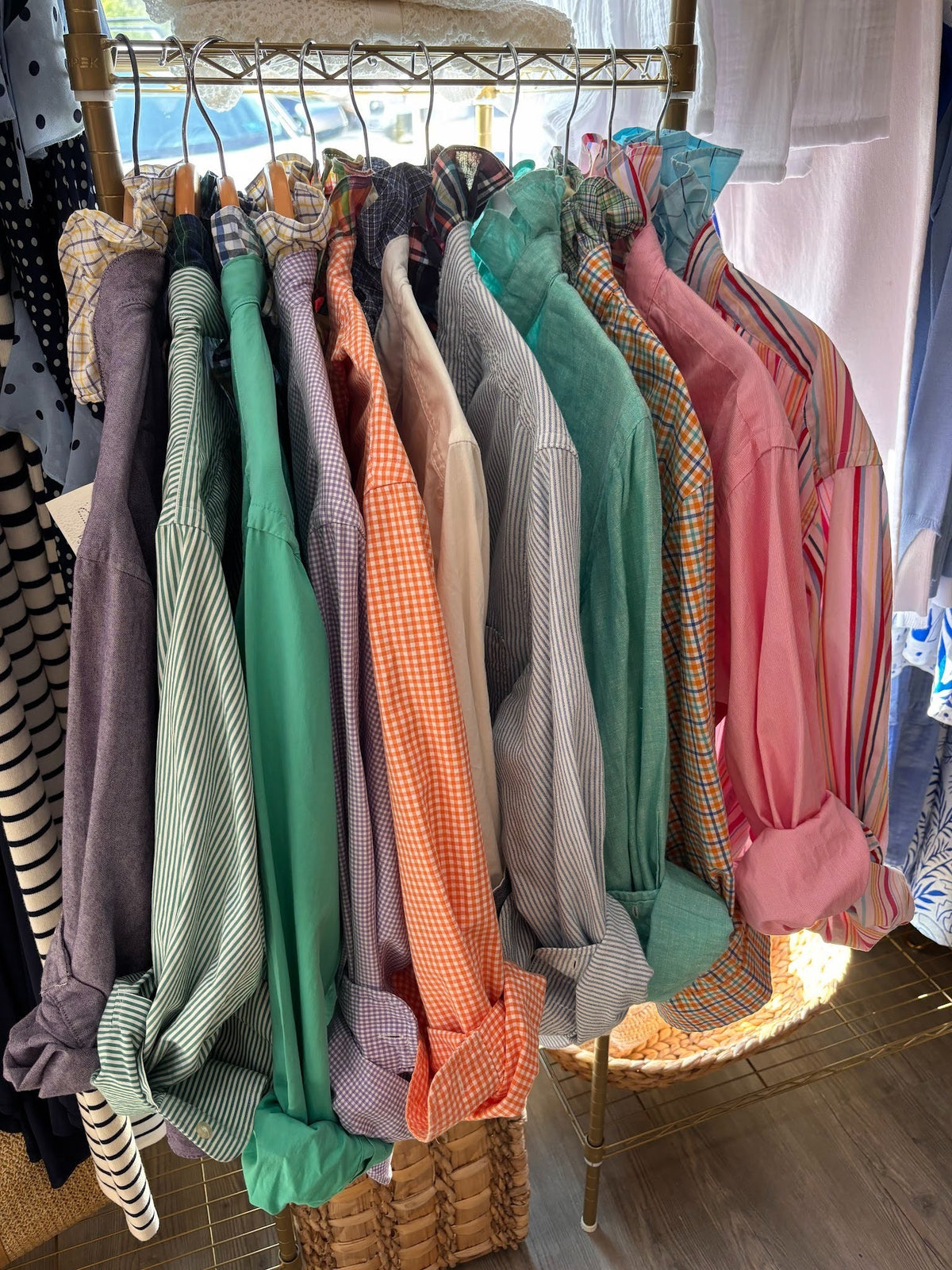 Hangers with various colorful shirts on a rack in a store setting